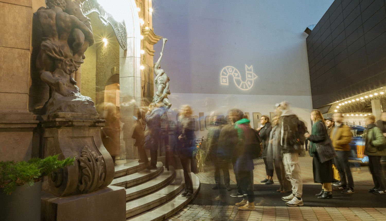 Apmeklētāji pie kino teātra ieejas