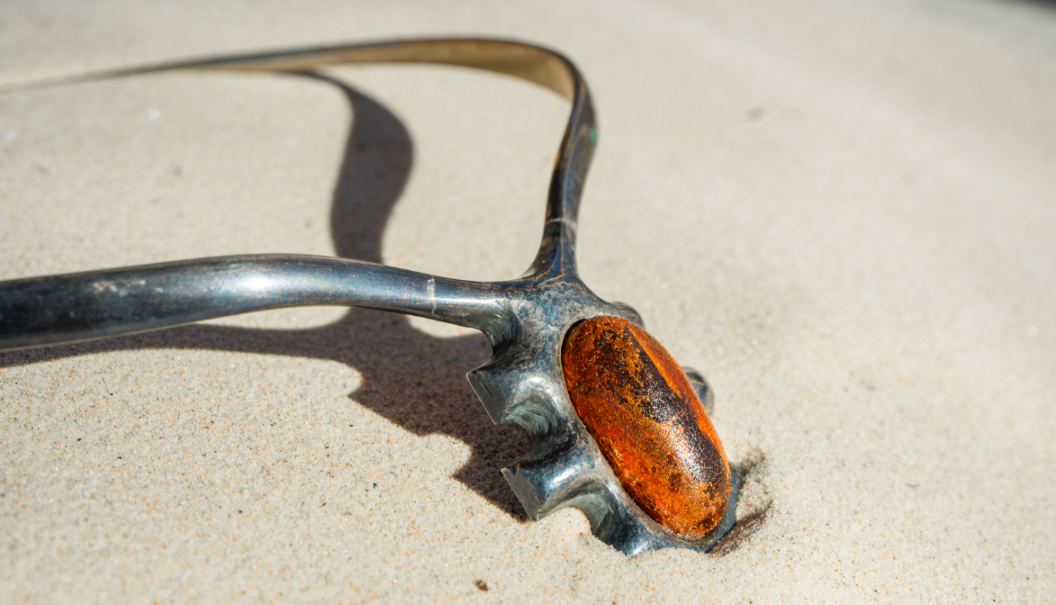 Darbs no izstādes - metāla rota ar krāsainu akmens elementu