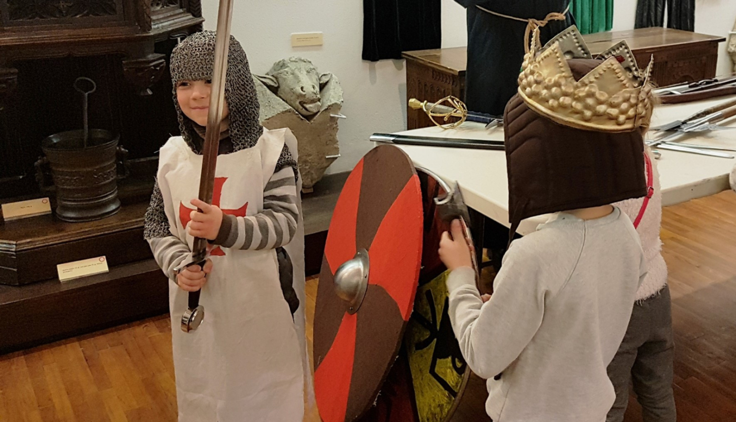 Bērni ietērpušies viduslaiku bruņinieku apģērba kopijās RVKM telpās