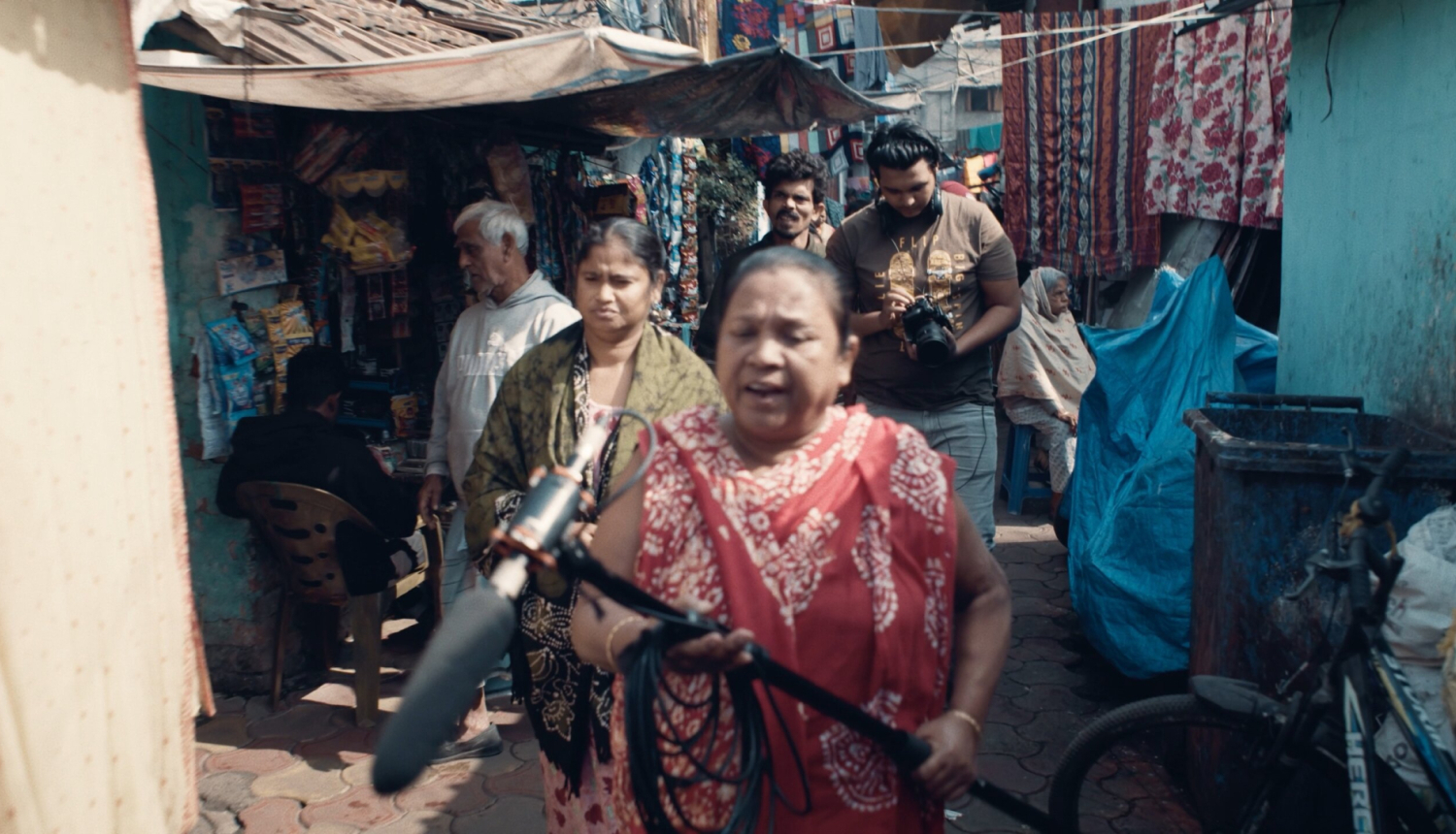 Kadrs no filmas “Sarkano lukturu cerību zvaigznes” ar Kaligatas sarkano lukturu ielu un cilvēkiem