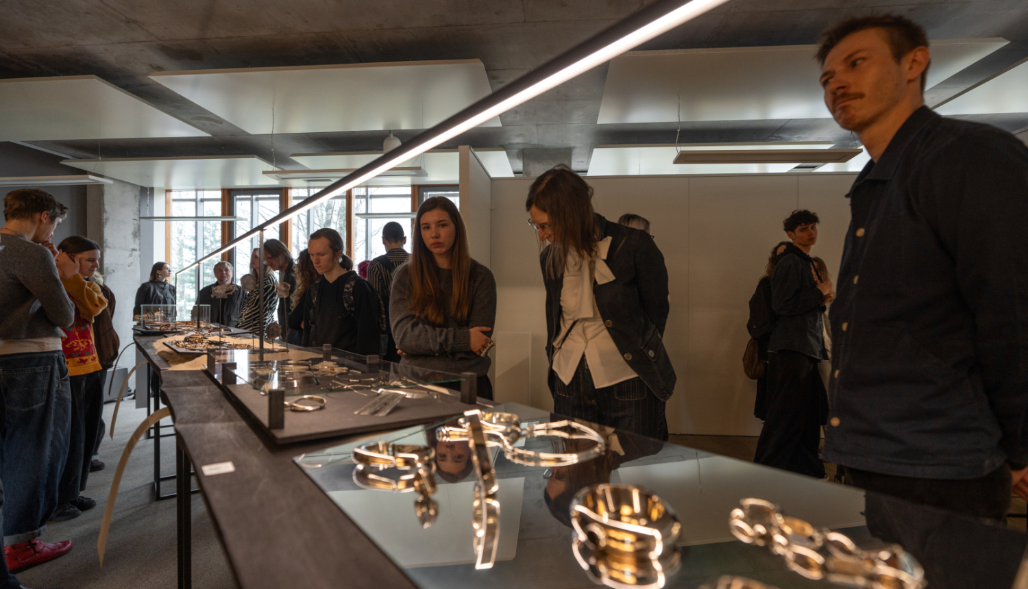 Izstādes apmeklētāji aplūko izstādes darbus