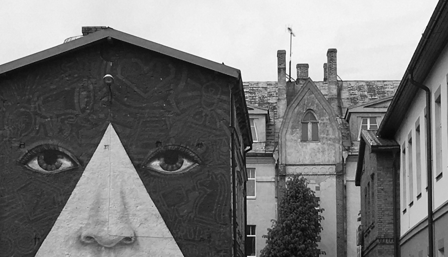 Asociatīvs foto: senas ēkas un murālis uz ēkas fasādes