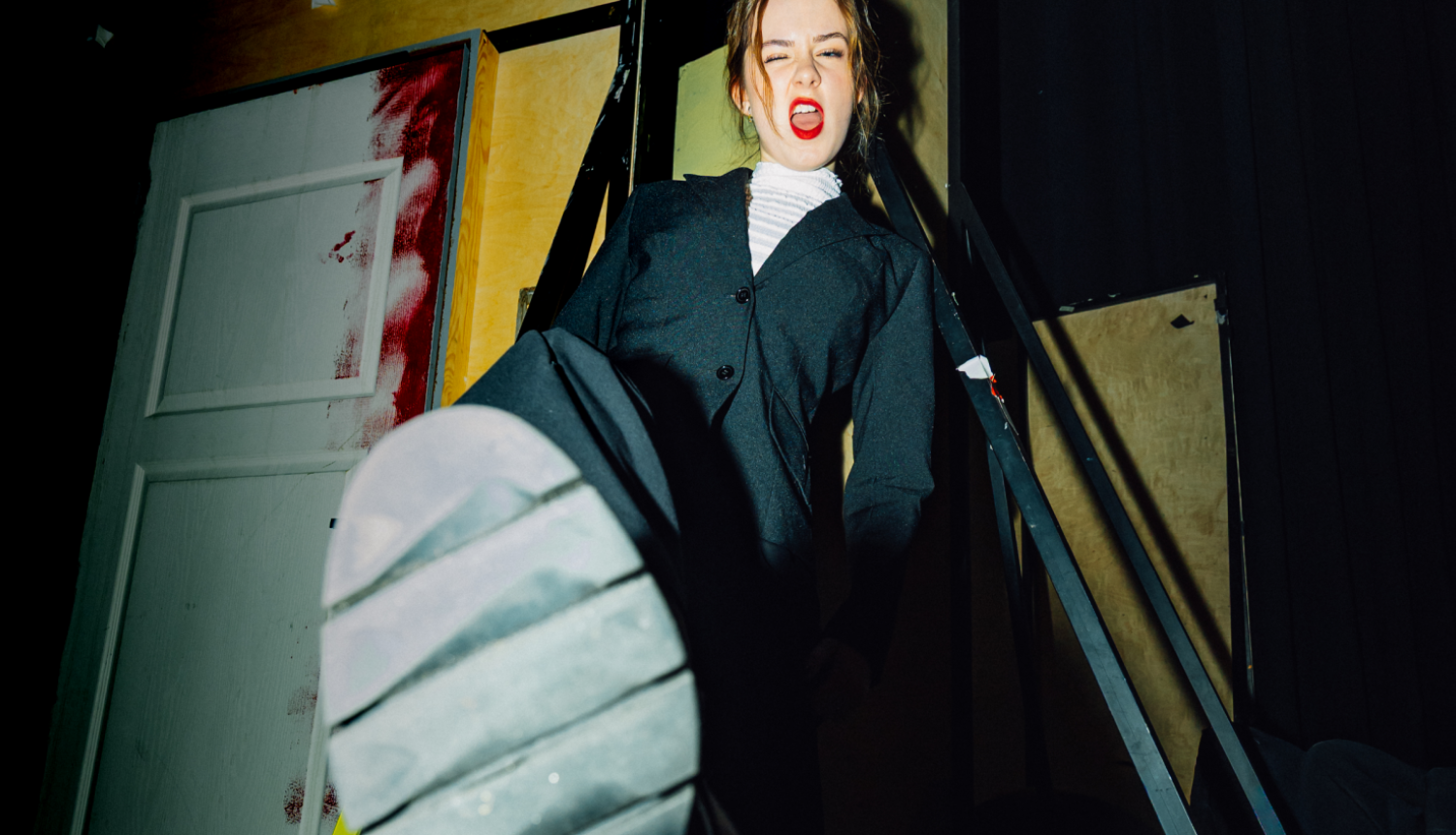 Jaunietis, kas izstiepis kurpes zoli pret attēla vidusdaļu