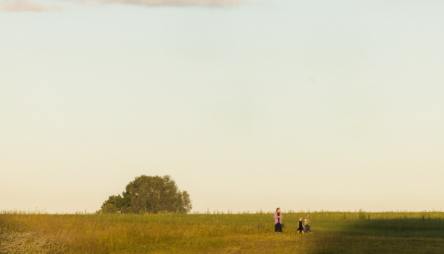 Dabas ainava - pļava ar koku talumā un cilvēkiem