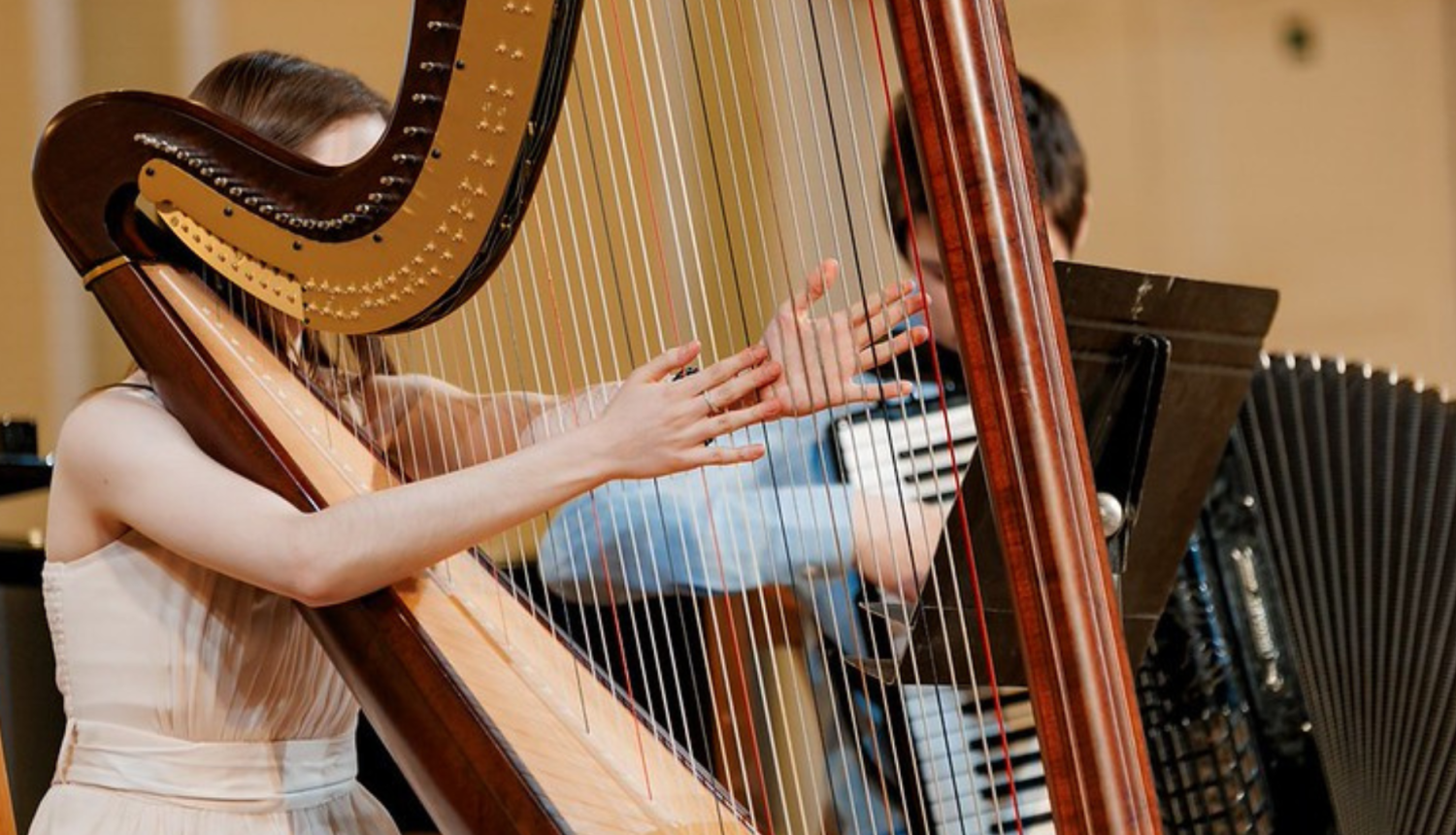 Meitene spēlē arfu uz skatuves