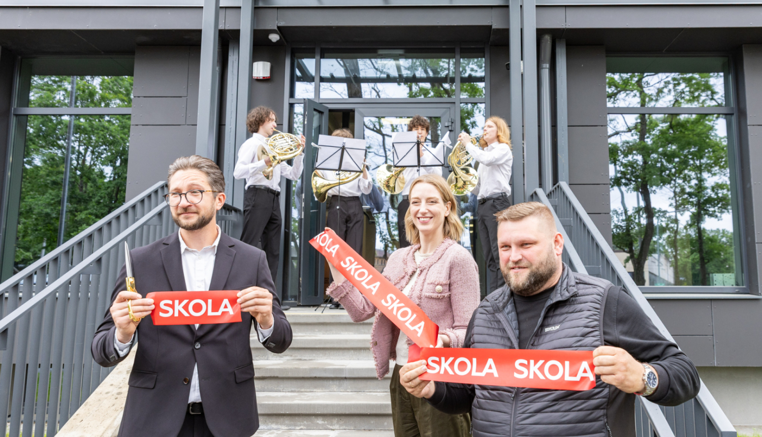 Trīs amatpersonas un mūziķi skolas ēkas atklāšanā