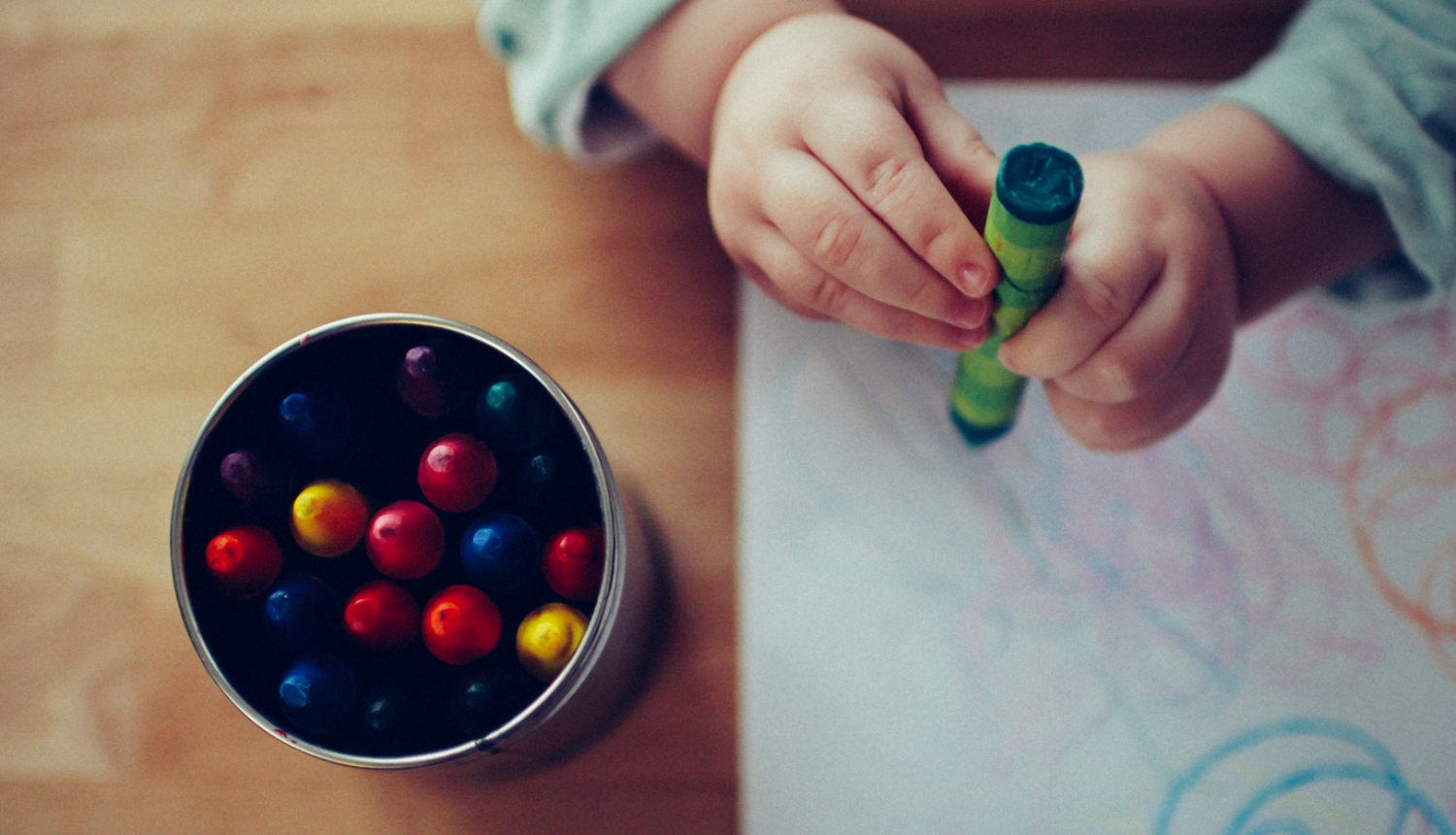 Bērna rokas un krāsaini krītiņi