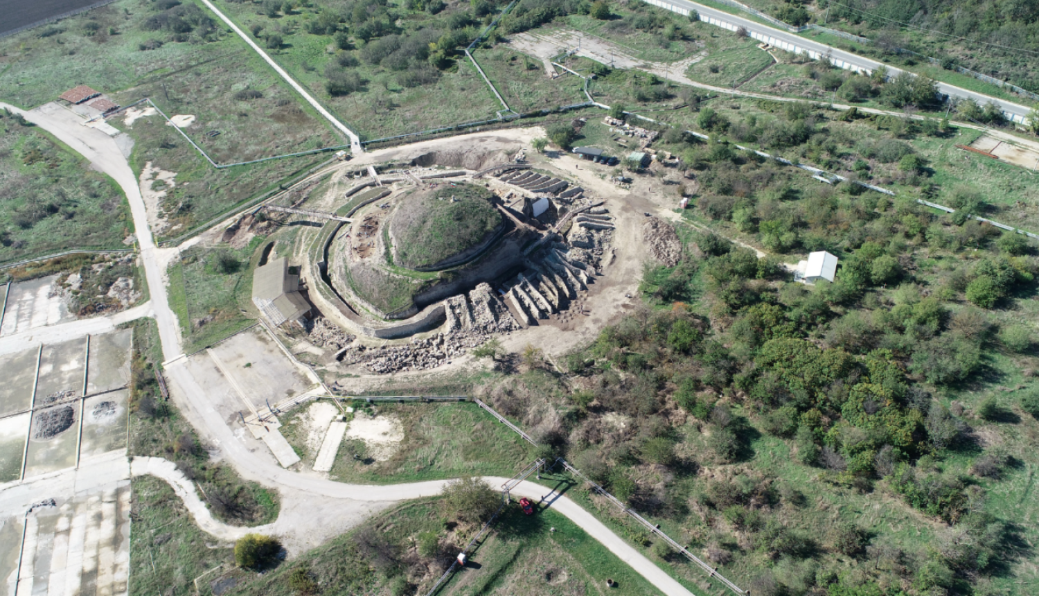 No gaisa fotografēta ainava ar zaļu vidi, centrā ir liels apaļš objekts - Provadijas sāls raktuves