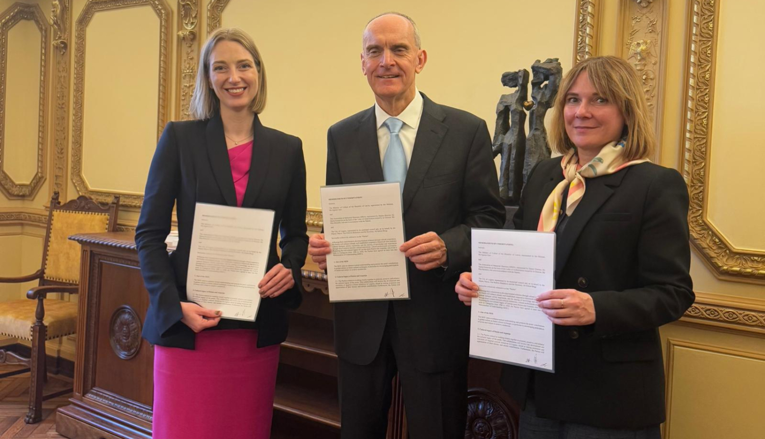 Trīs cilvēki memoranda parakstīšanas brīdī