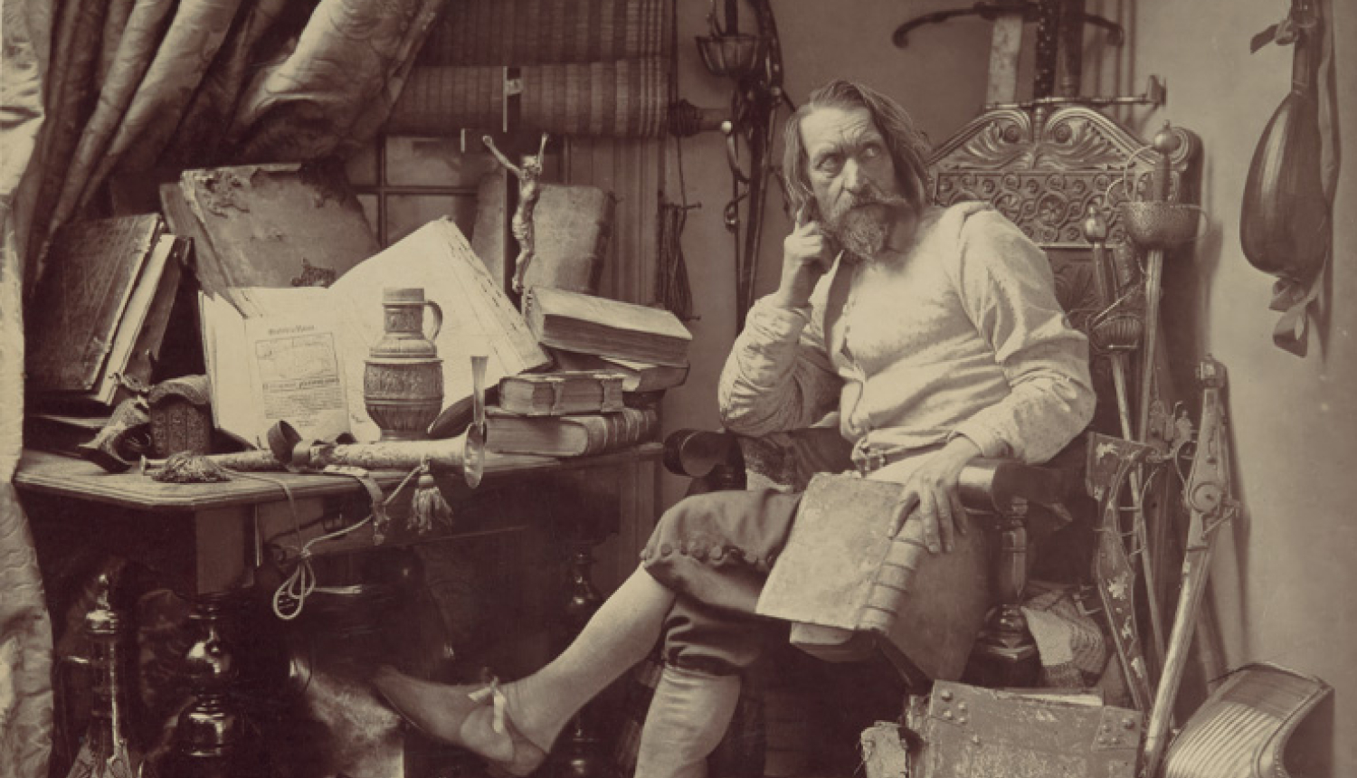 Izrādes "Dons Kihots" publicitātes attēls - attēls sēpijas toņos, pie galfa sēž izrādes tēls