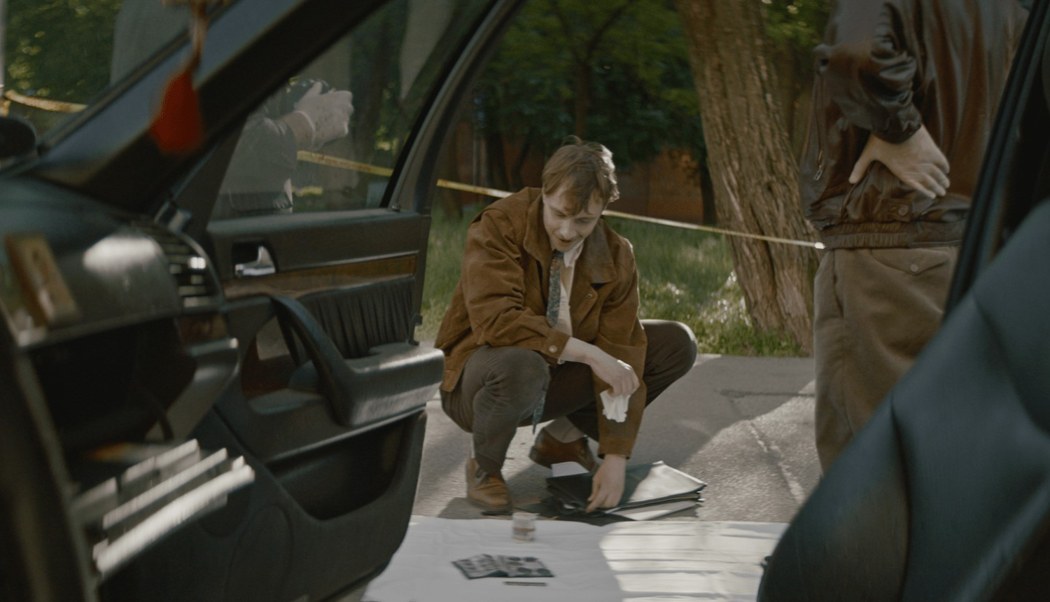 Vīrietis pie mašīnas. Kadrs no filmas.