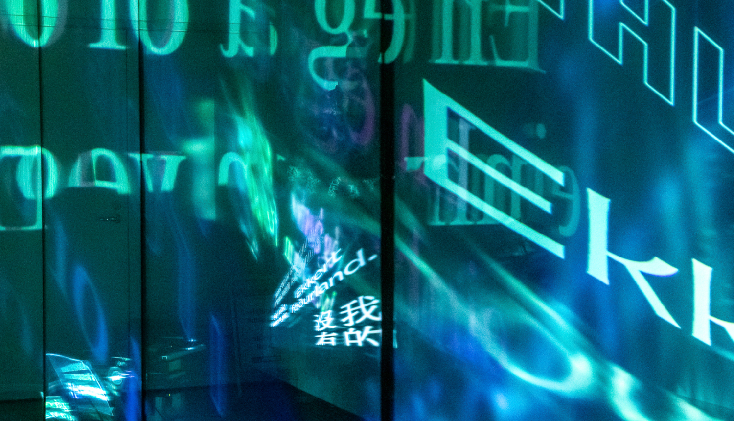 Dekoratīvs krāsu plūdums zilos un zaļos toņos, izklaidus burti E, k, H u.c