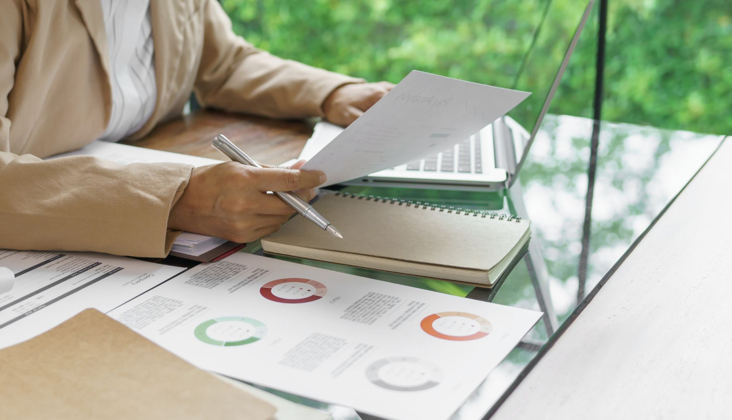 Darba galds, dators un papīra lapas ar diagrammām