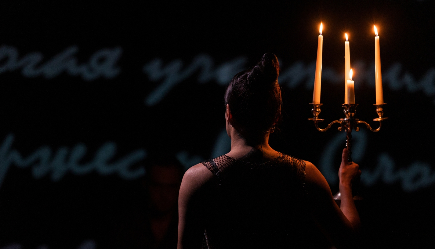 Sieviete ar iedegtām svecēm uz skatuves