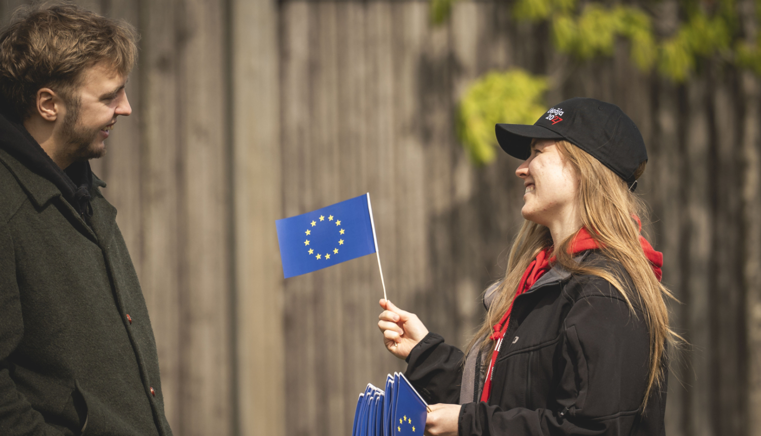 Sieviete tur papīra Eiropas Savienības karodziņus, piedāvā vienu vīrietim