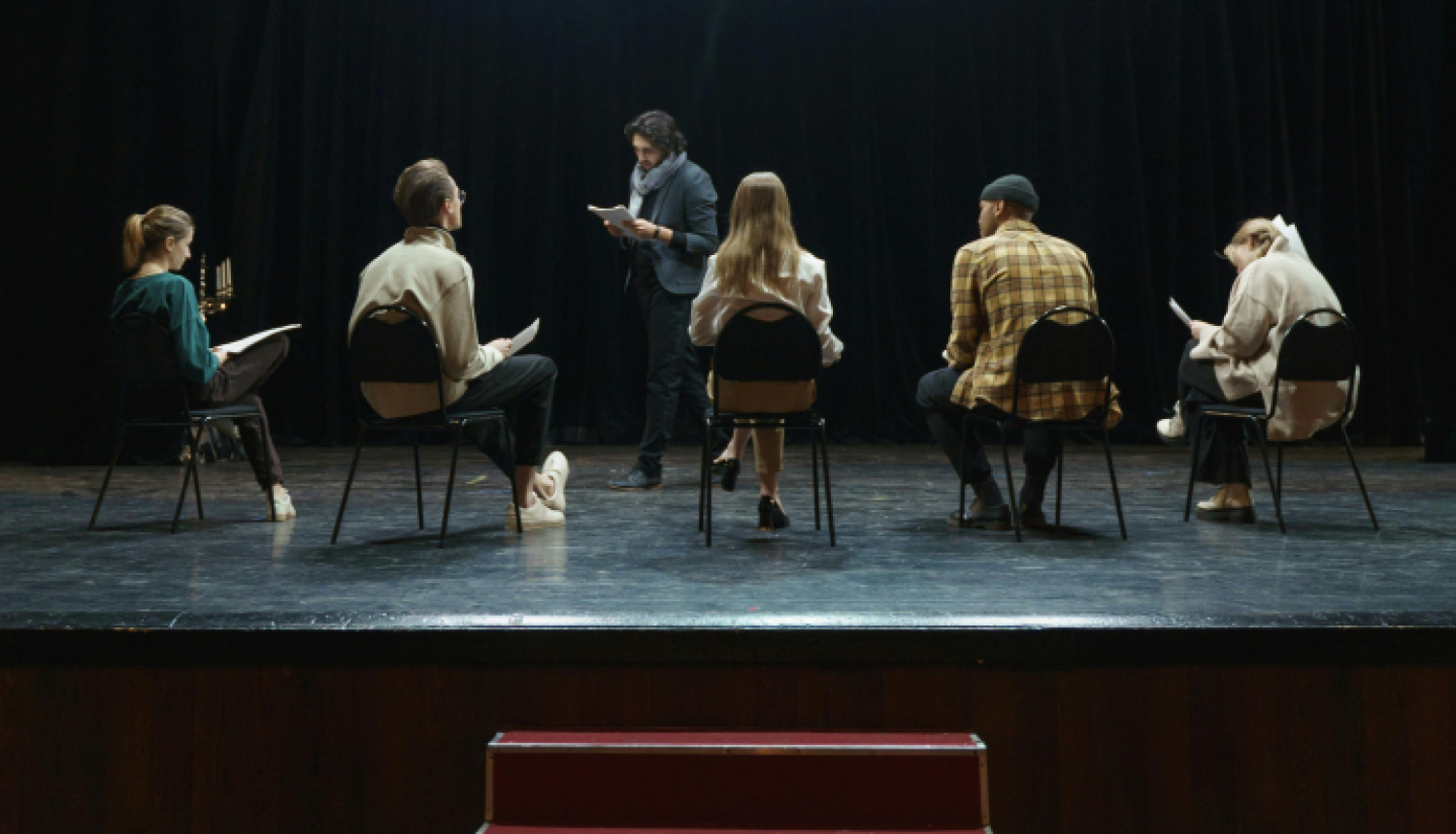 Seši aktieri uz skatuves mēģinājuma procesā