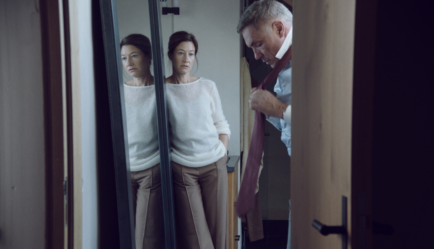 Filmas kadrs - sieviete un vīrietis pavērtās durvīs