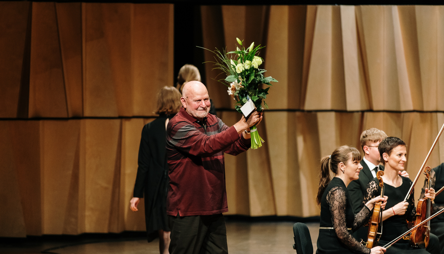 Komponists Pēteris Vasks uz skatuves Cēsu koncertzālē saņemot ziedus
