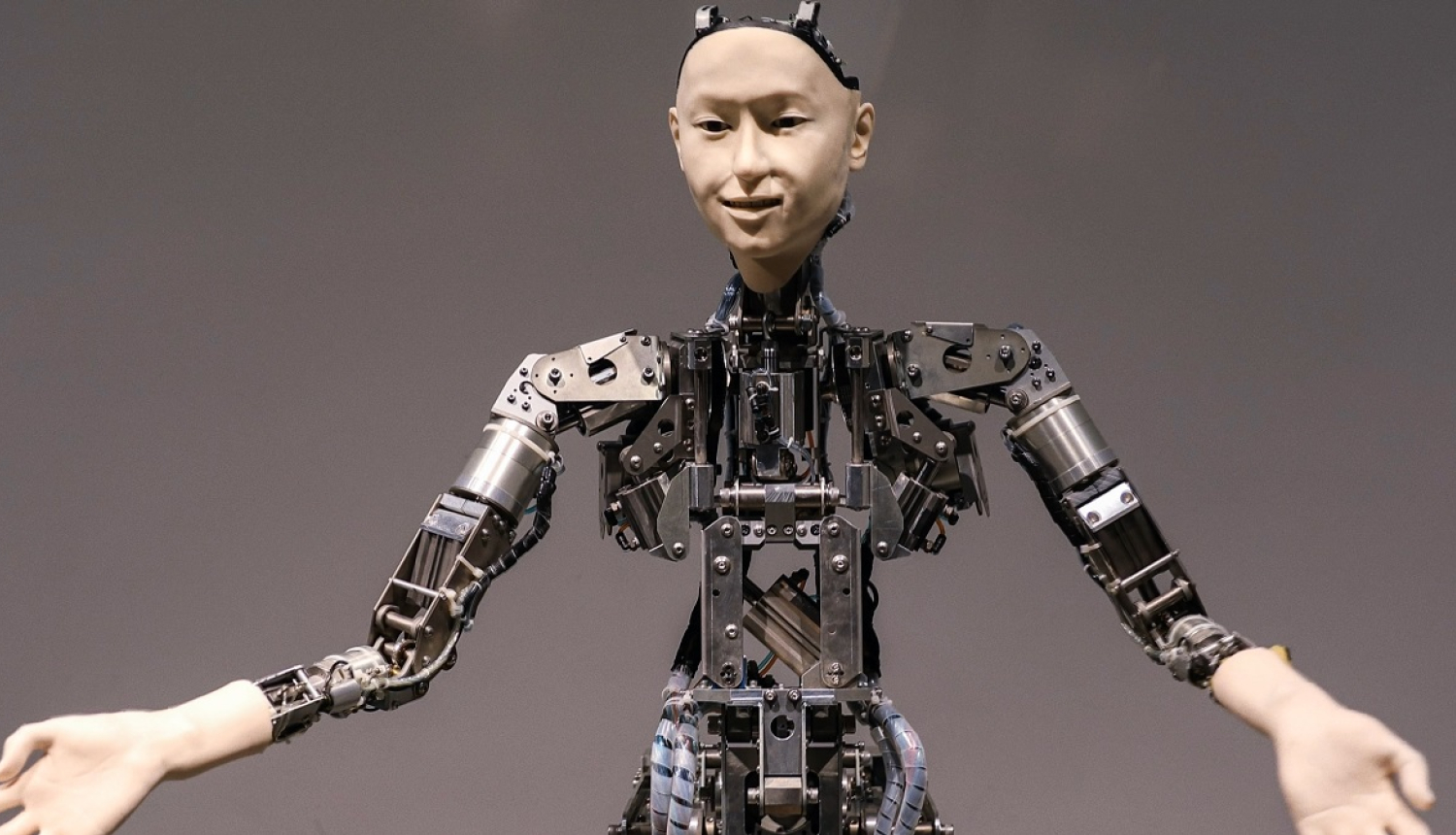 Cilvēkveidīga robota portrets ar izstieptām rokām