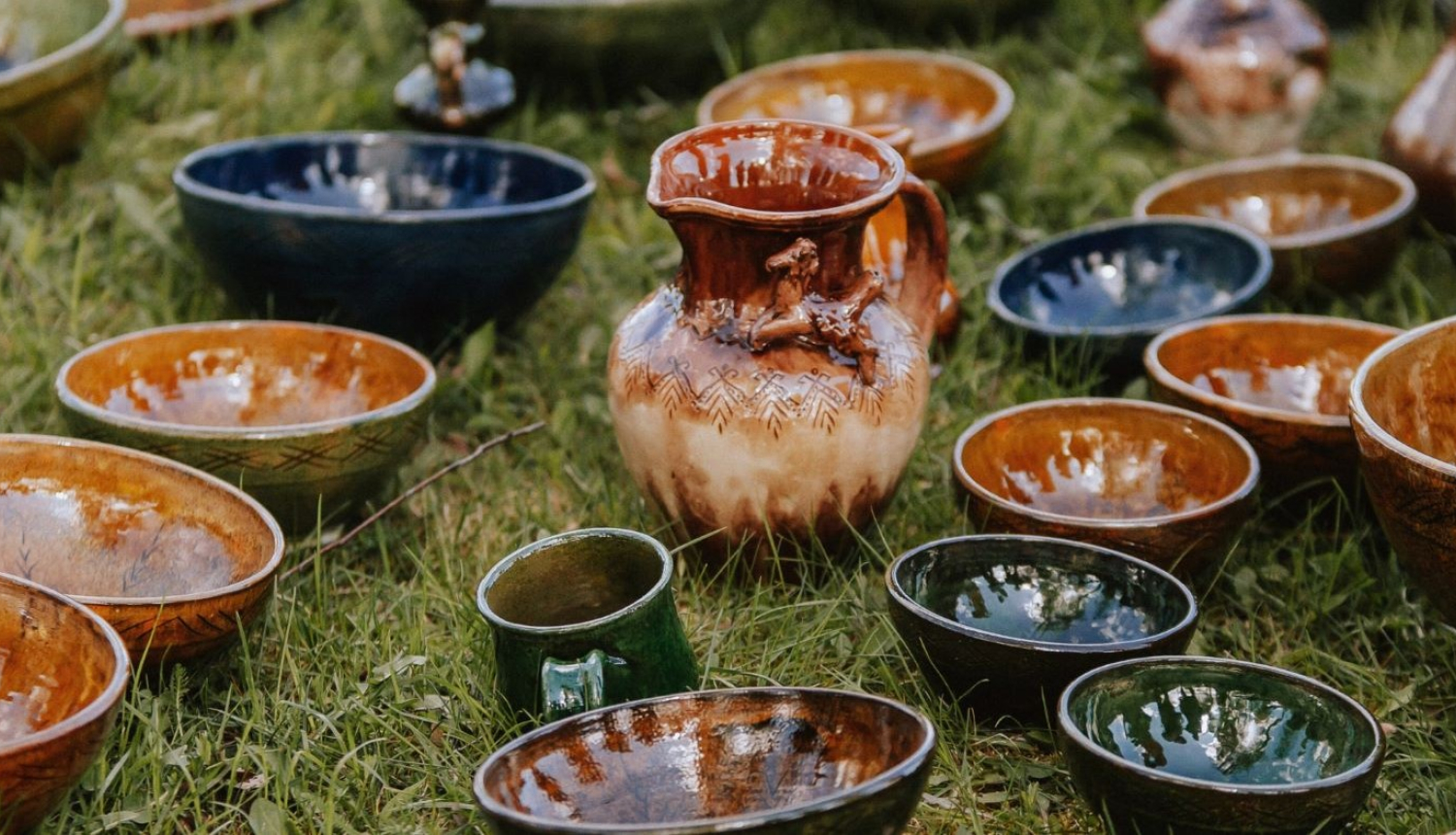 Māla trauki izstādīti zālienā - krūkas, vāzes un bļodas