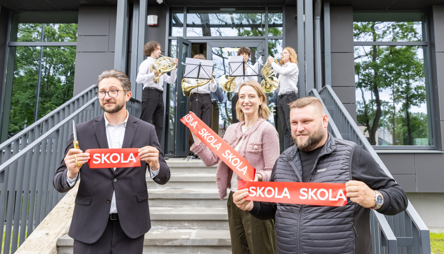 Trīs amatpersonas un mūziķi skolas ēkas atklāšanā