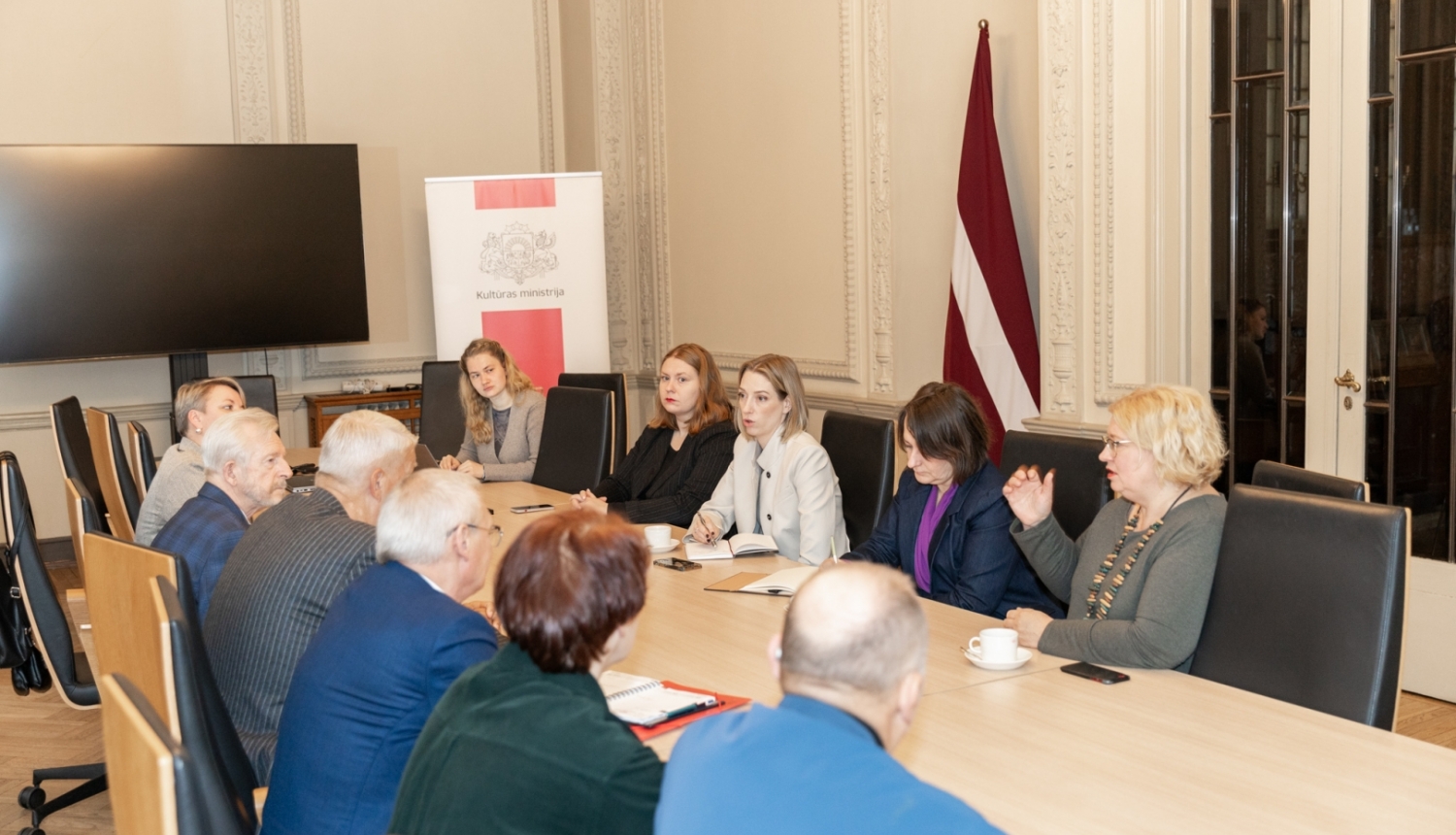 Cilvēki pie sanāksmju galda