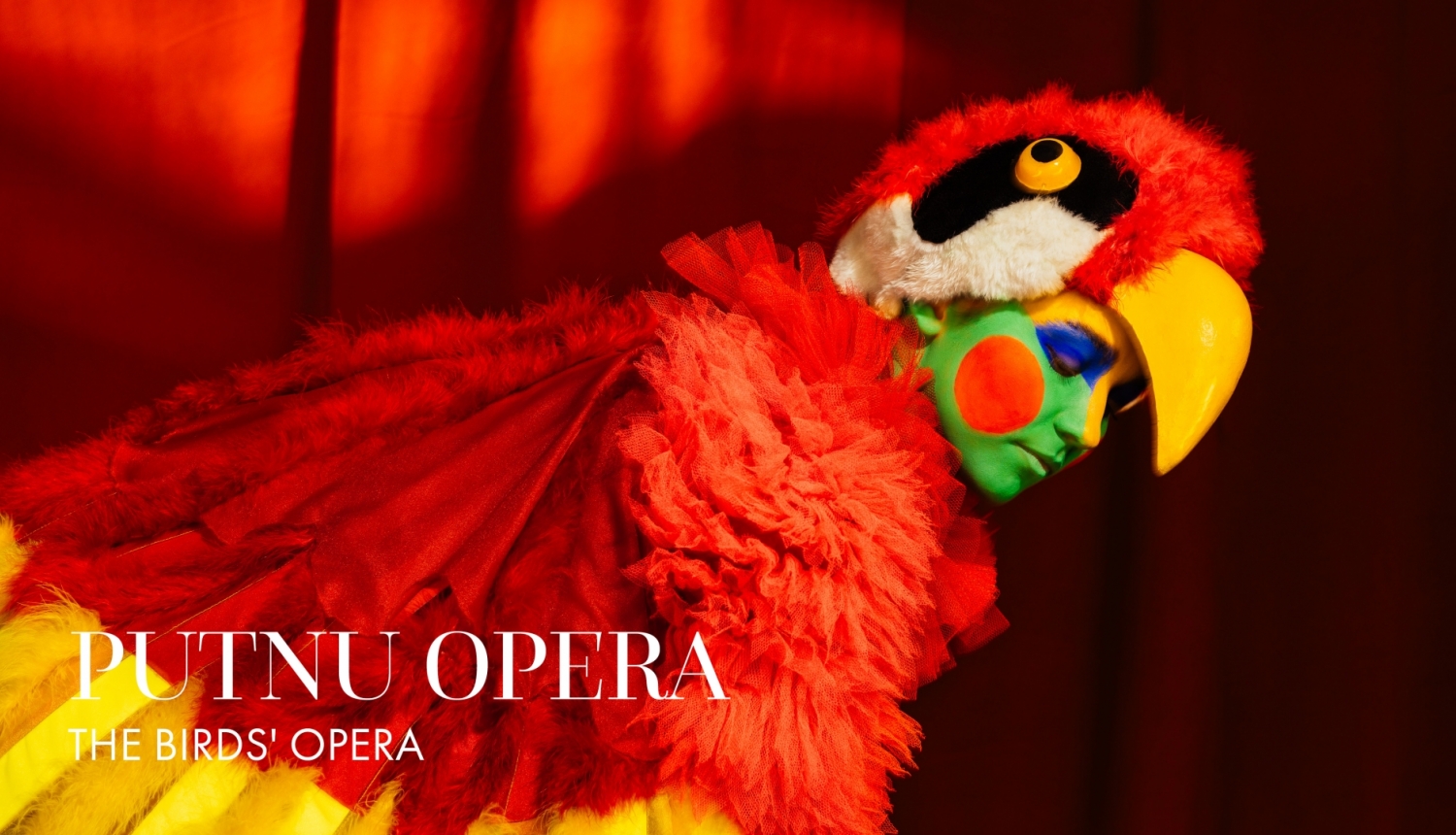 Afiša ar aktiera foto papagaiļa kostīmā un uzrakstu : Putnu opera