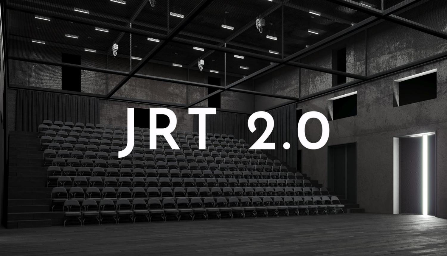 Balts uzraksts "JRT 2.0", fonā skatītāju vietas Jaunā Rīgas teātra pagaidu telpās Tabakas fabrikā
