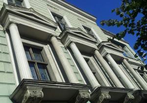 Ēkas fasādi rotā rusti un ar izteiksmīgiem frontona tipa sandrikiem akcentētas logailu grupas. Vietām jumta dzegu papildina balustrāde. Foto: Jānis Dripe