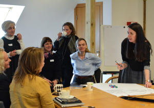 Semināra norise, dalībnieki pie galda diskutē